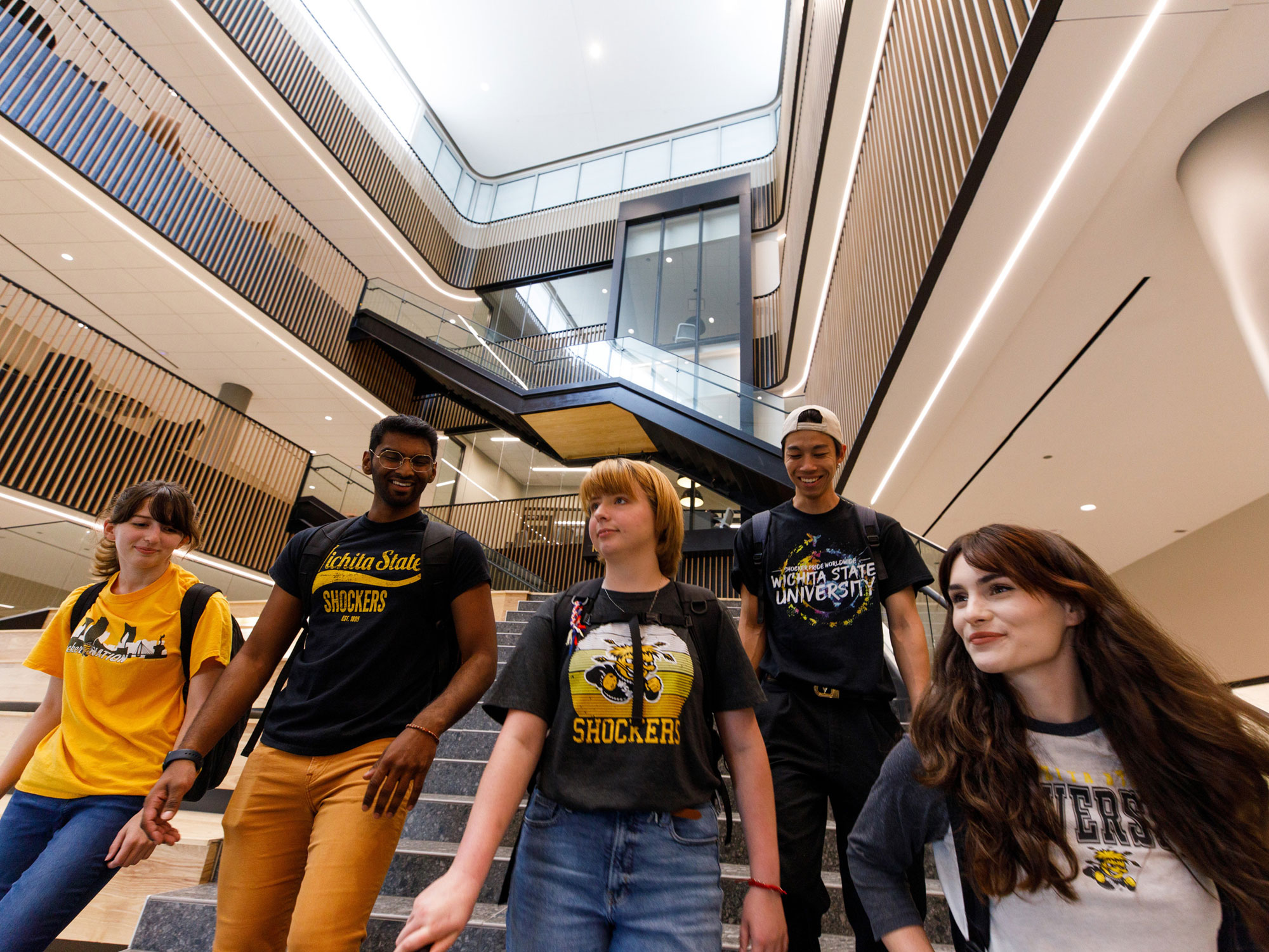 Diverse group of students walking down Woolsey Hall steps