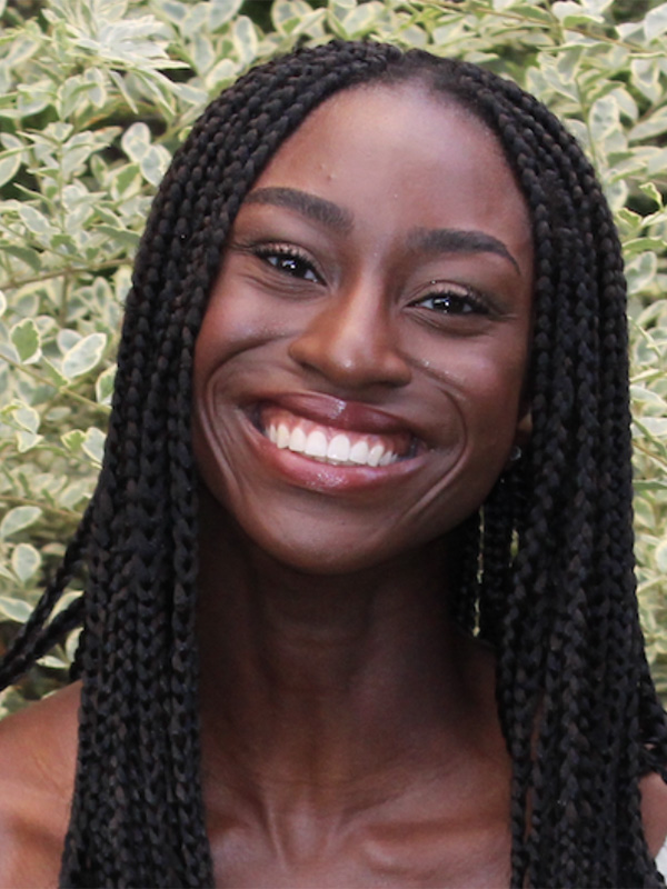 Chinelo Ogogor standing in front of a leafy background