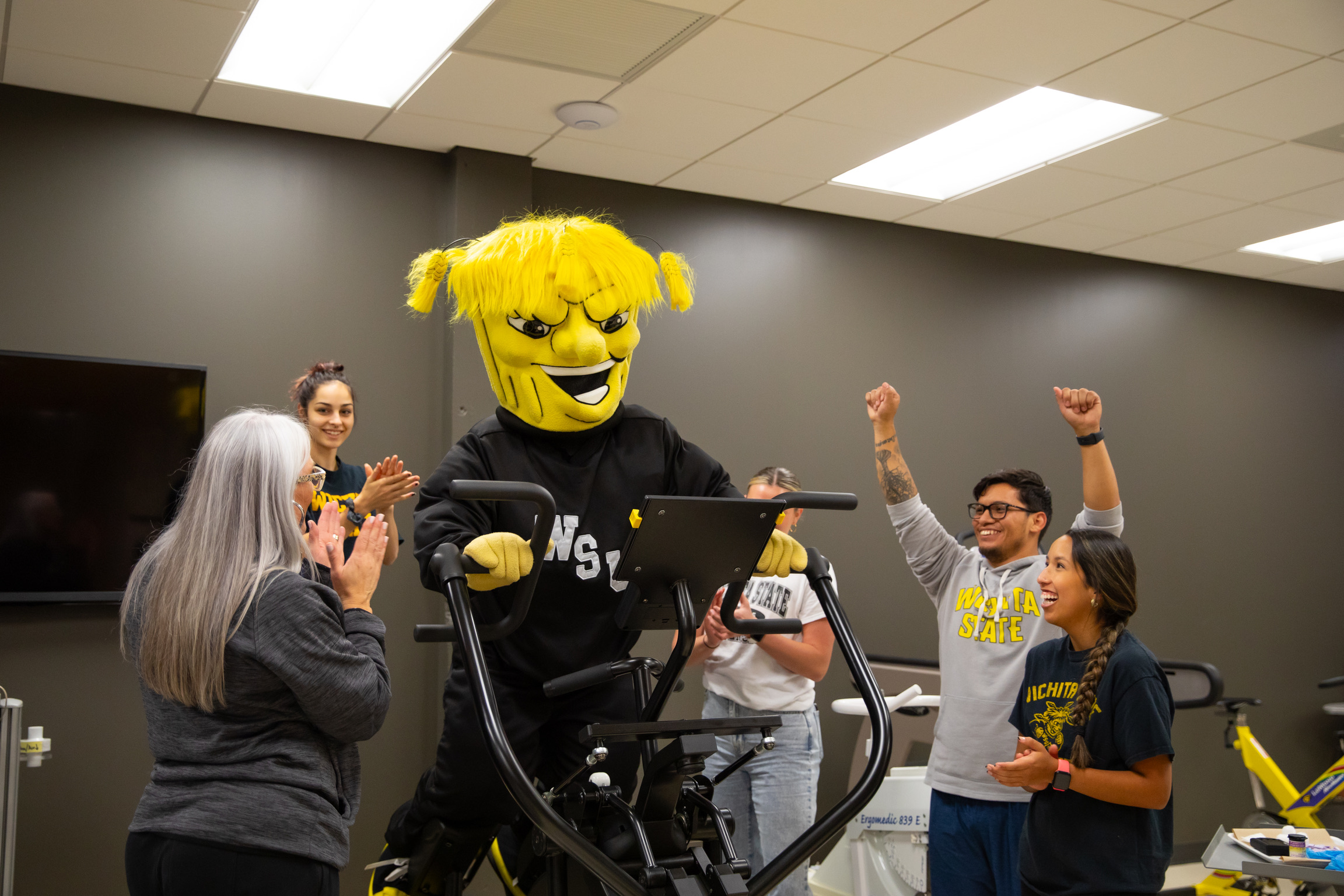 Athletic Training Students cheer on WU as the mascot uses an elliptical