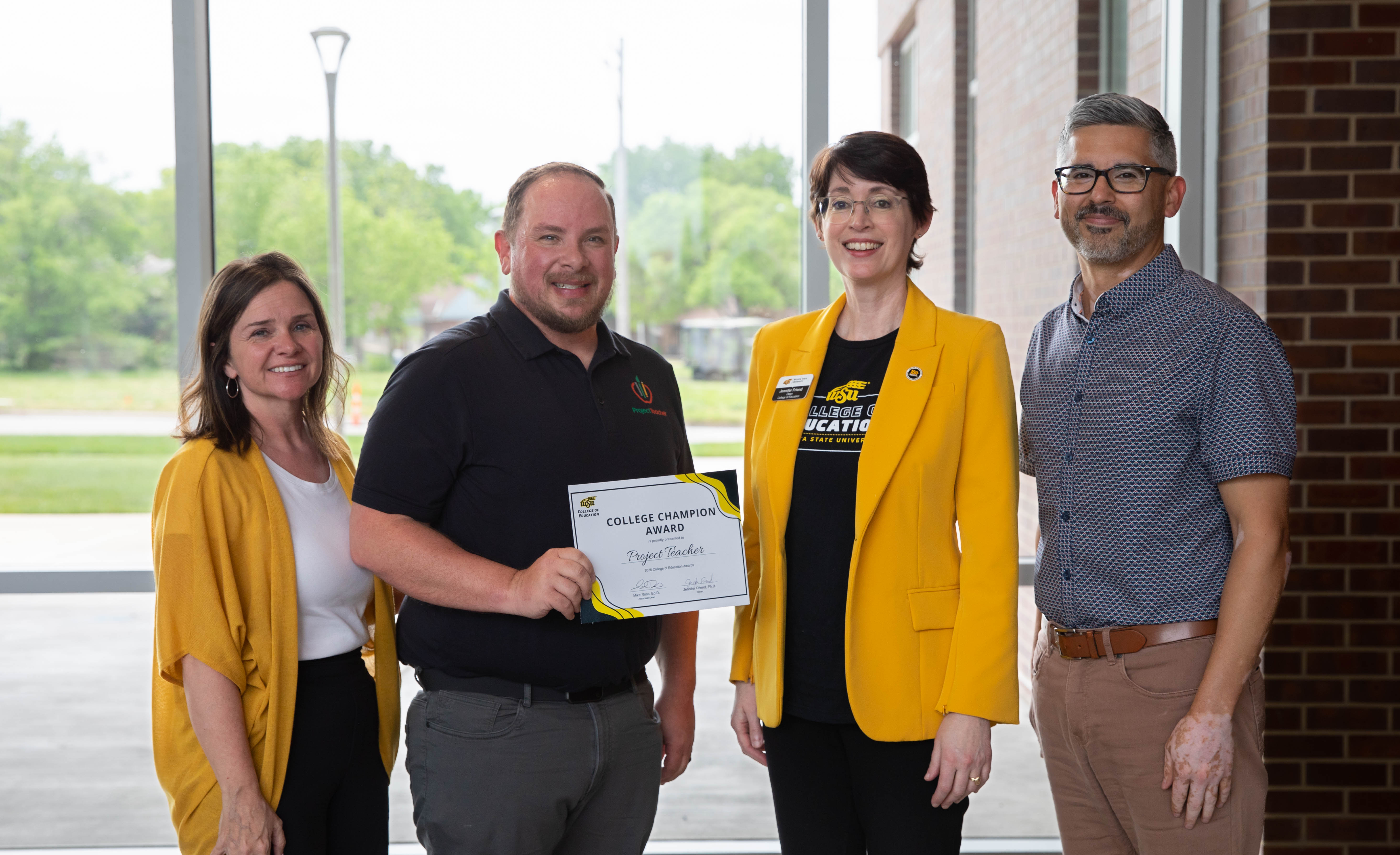 Members of Project Teacher stand together holding a College Champion Award certificate with Dr. Jennifer Friend, dean of the College of Education.