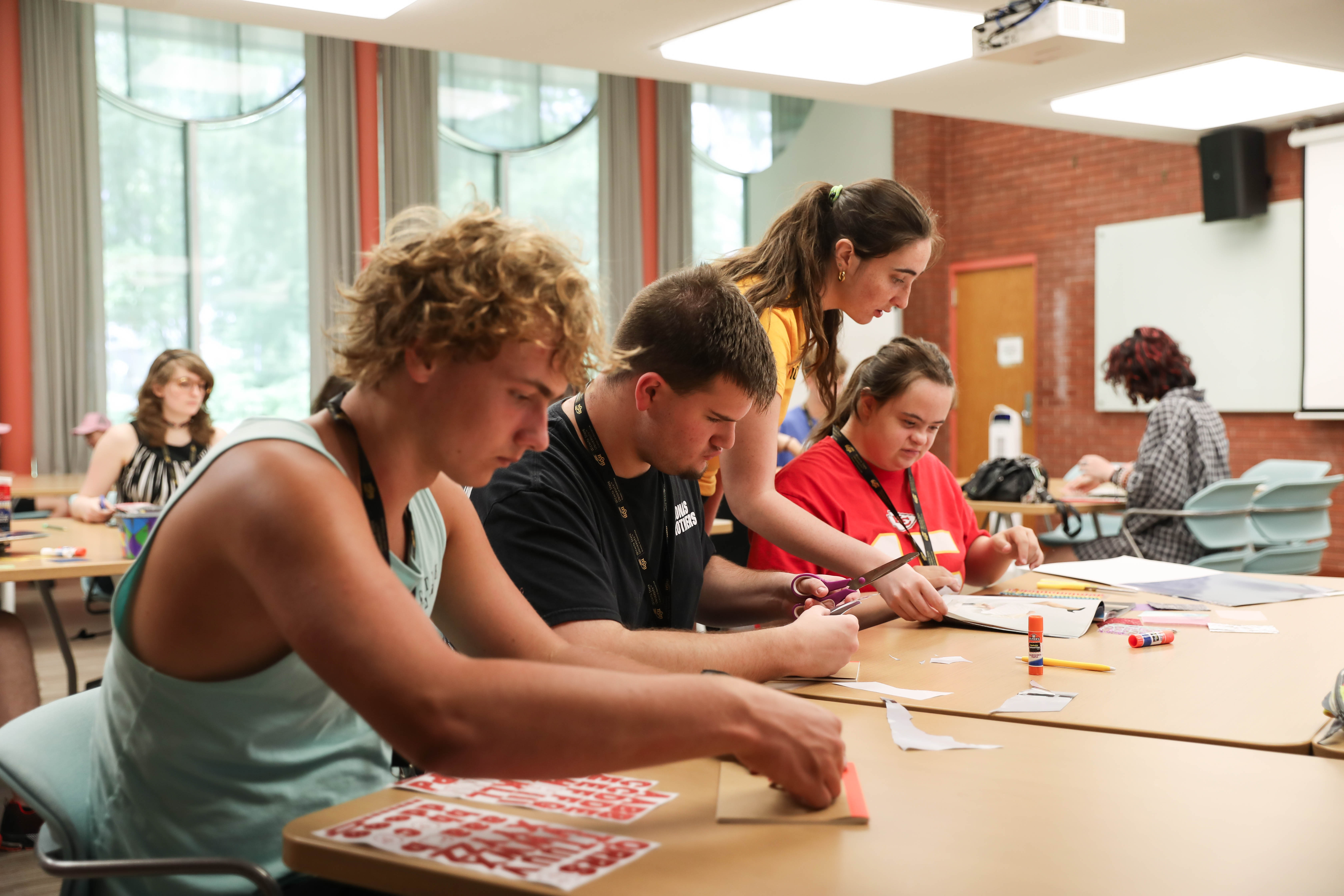 Wichita State LIFE summer camp participants work on art projects with camp mentors.