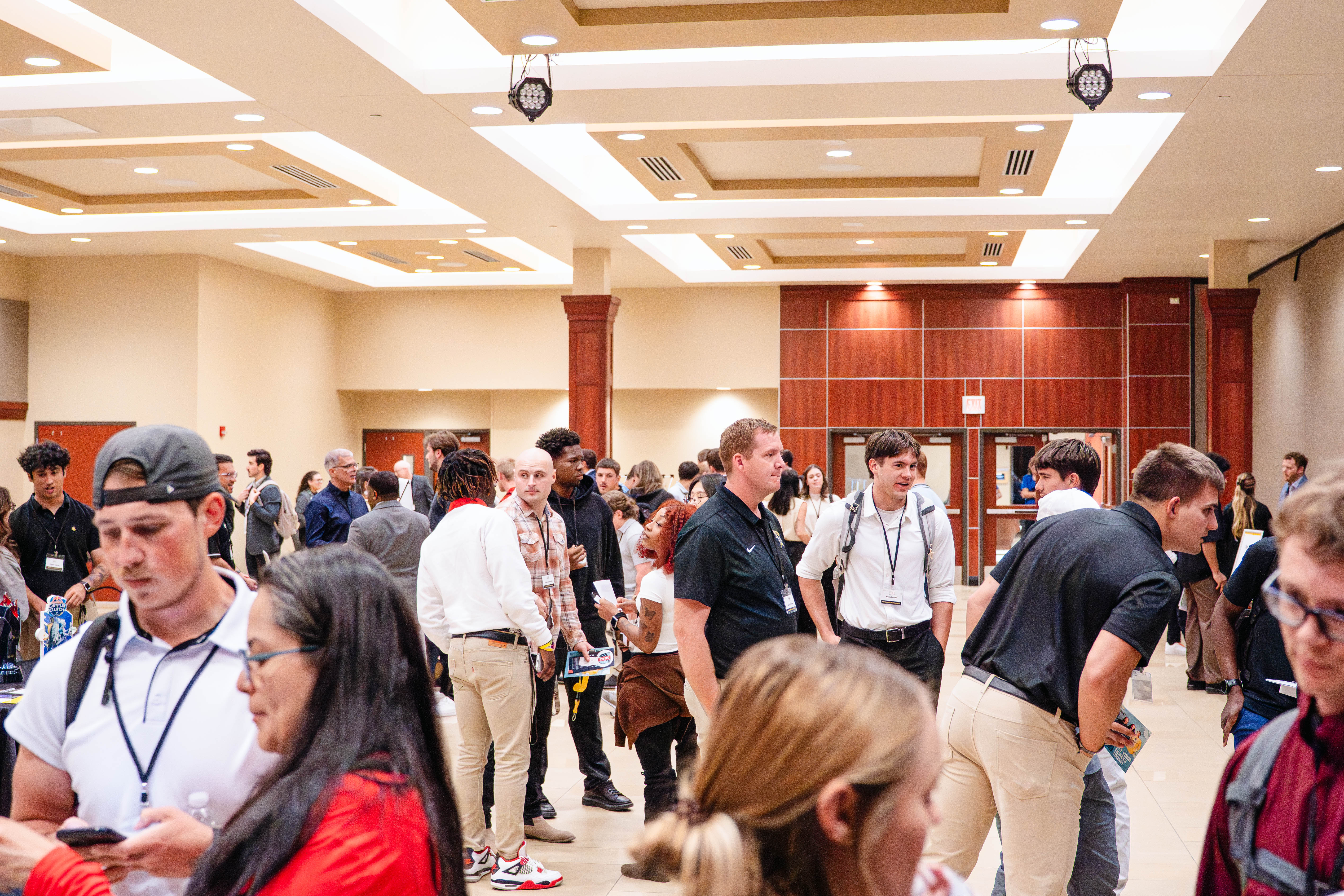 Attendees network and interact in a large open space during the Kansas Sport Summit at Wichita State University.