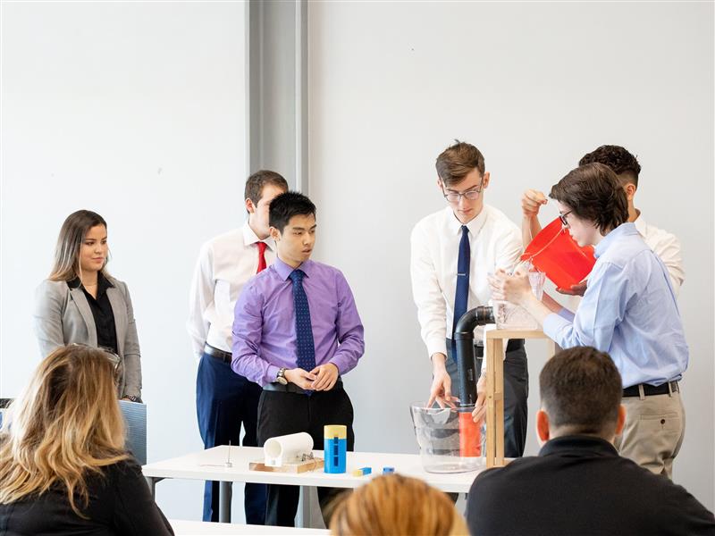 A team of students presenting their prototype to a panel of judges
