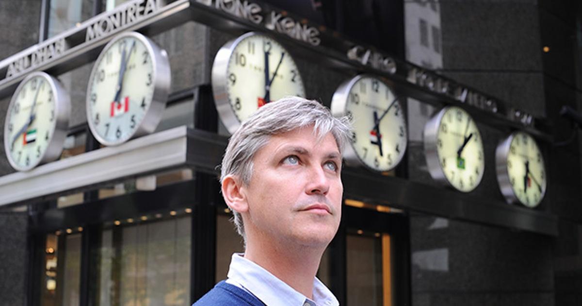 Steven Johnson standing in front of international clocks