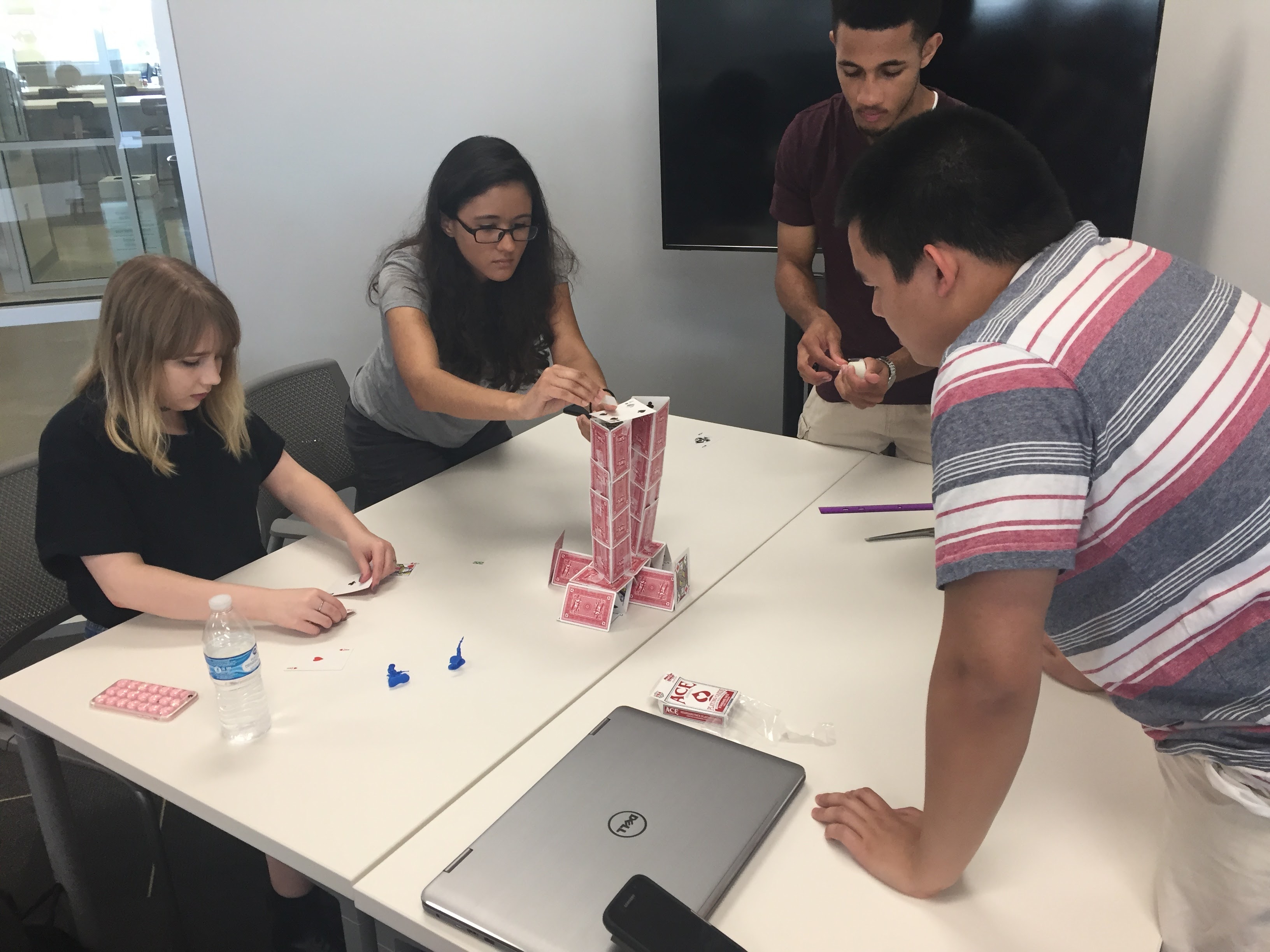 Students building a house of playing cards
