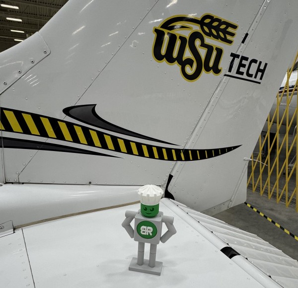 Manny visiting WSU Tech Manny (mascot) sitting on tail of a Cessna at WSU Tech