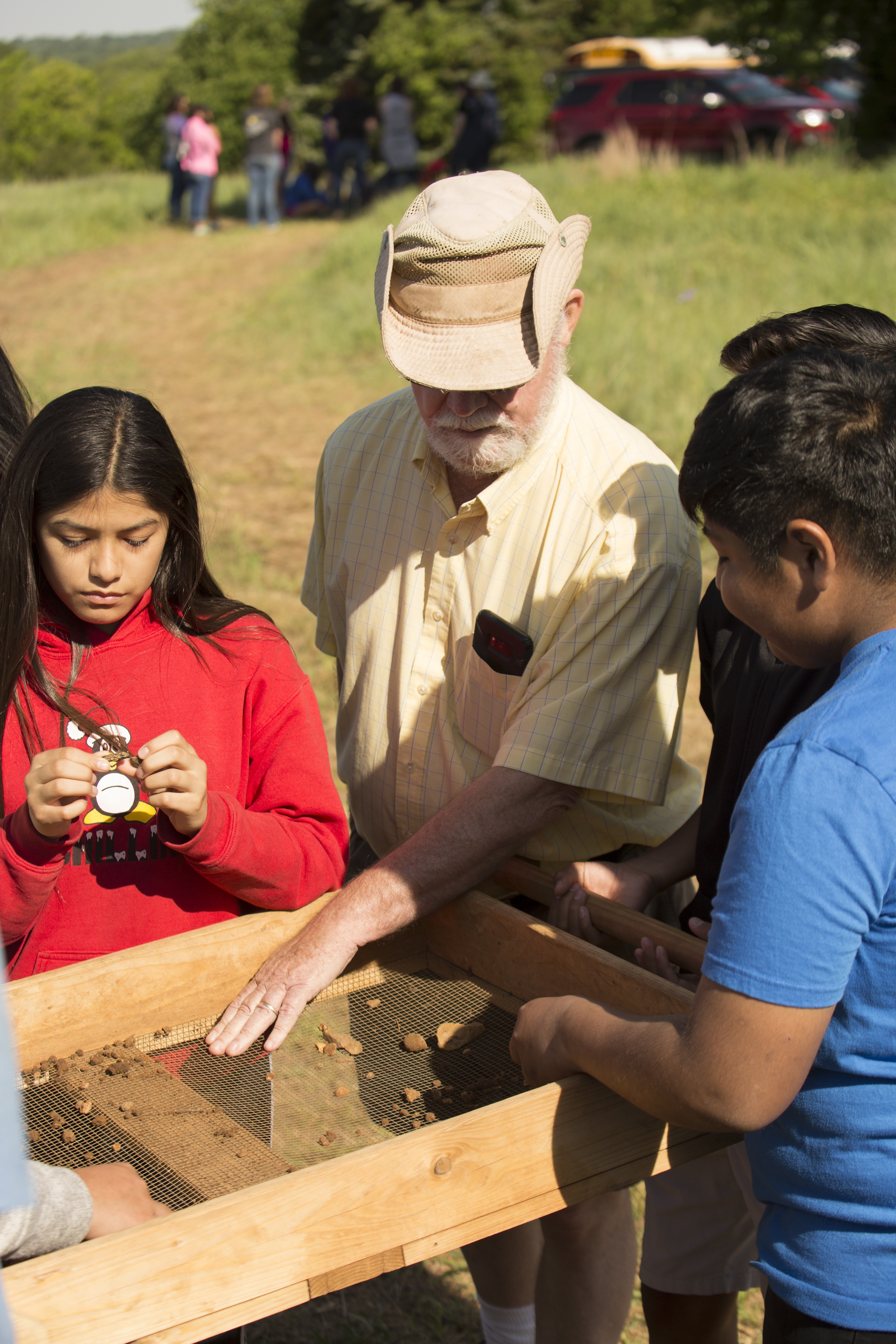 Photo Credit Matt Gush older white man at archaeology sifting screen with young girl