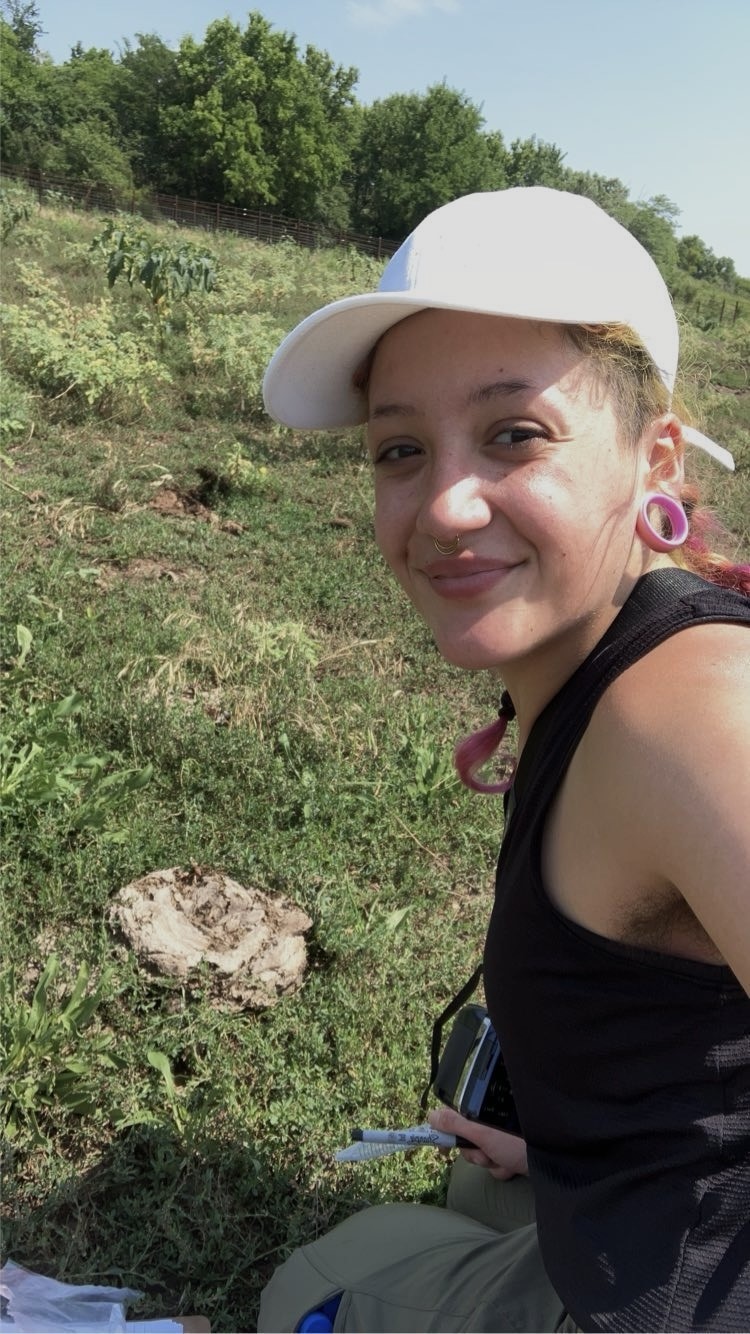 headshot of person with green hair and gauged ears
