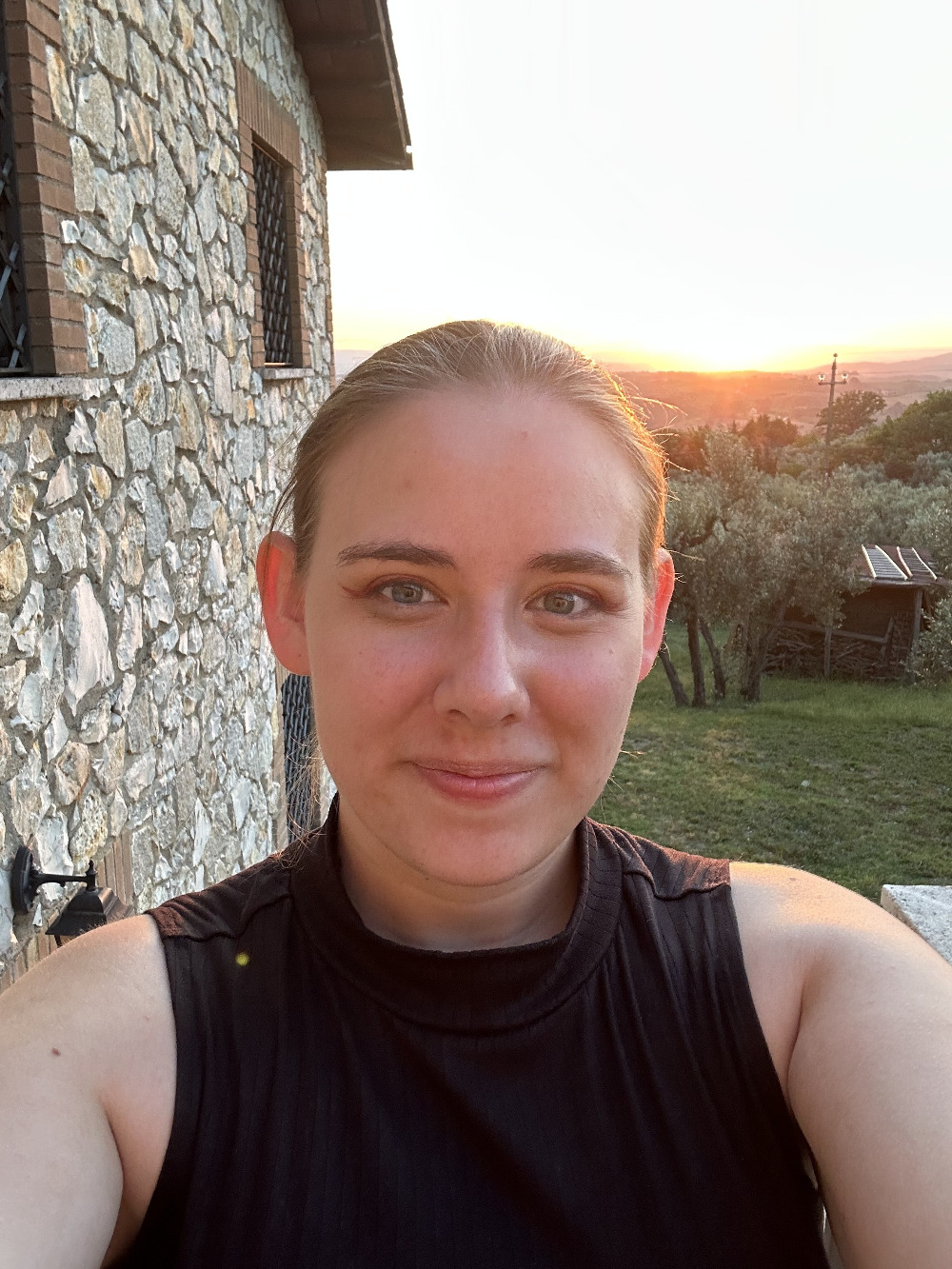 white woman with hair pulled back in front of sunset