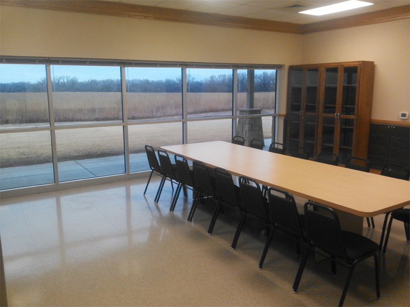 Ninnescah Field Station Building interior, with a large window to the reserve and a long table with multiple chairs on both sides
