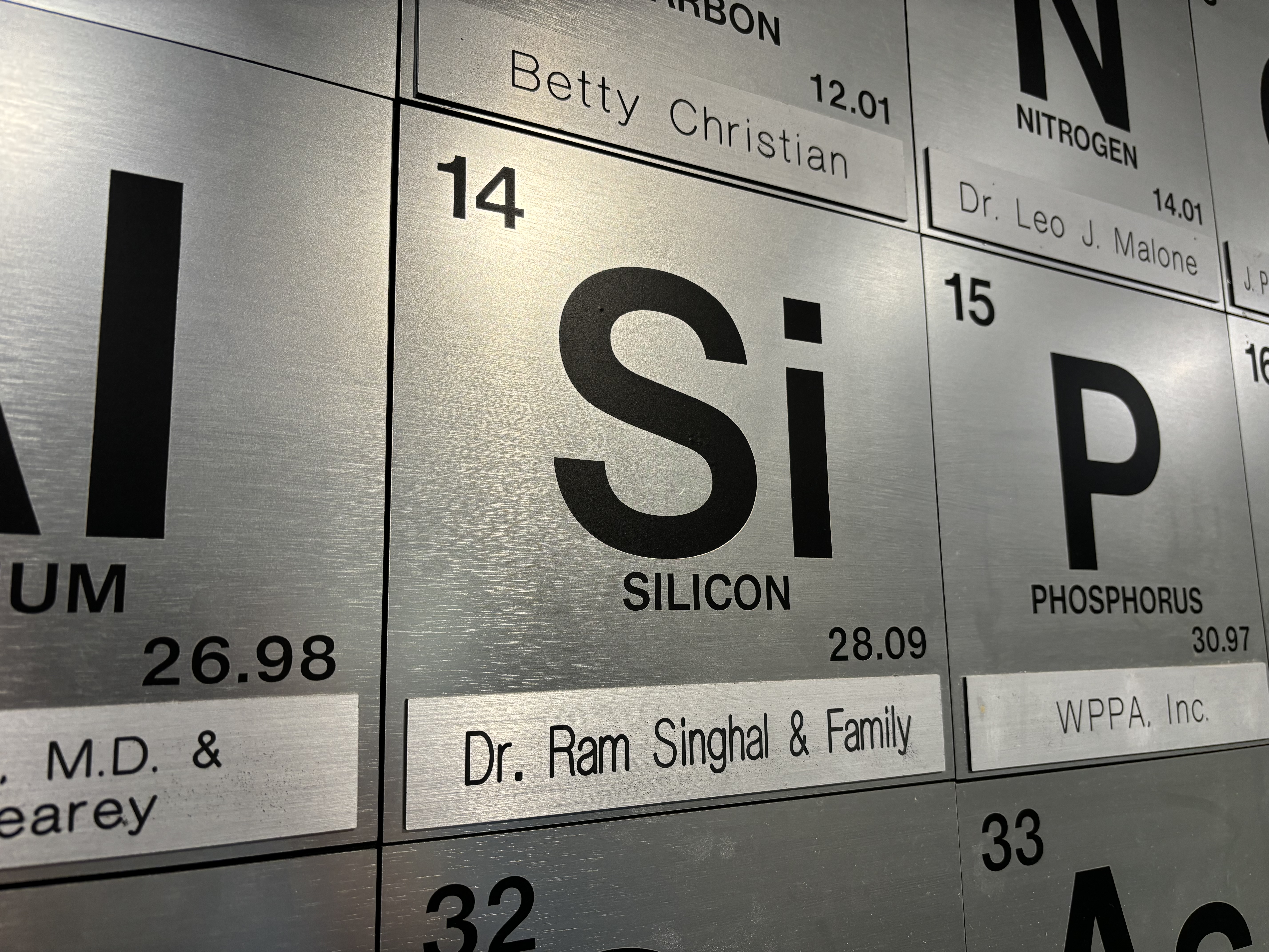 Close-up view of periodic table element showing donor nameplates on each element