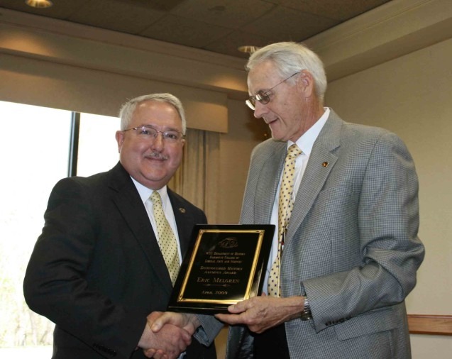 placeholderUnited States District Judge Eric J. Melgren, left, receives the department’s Distinguished Alumnus Award from John Dreifort.