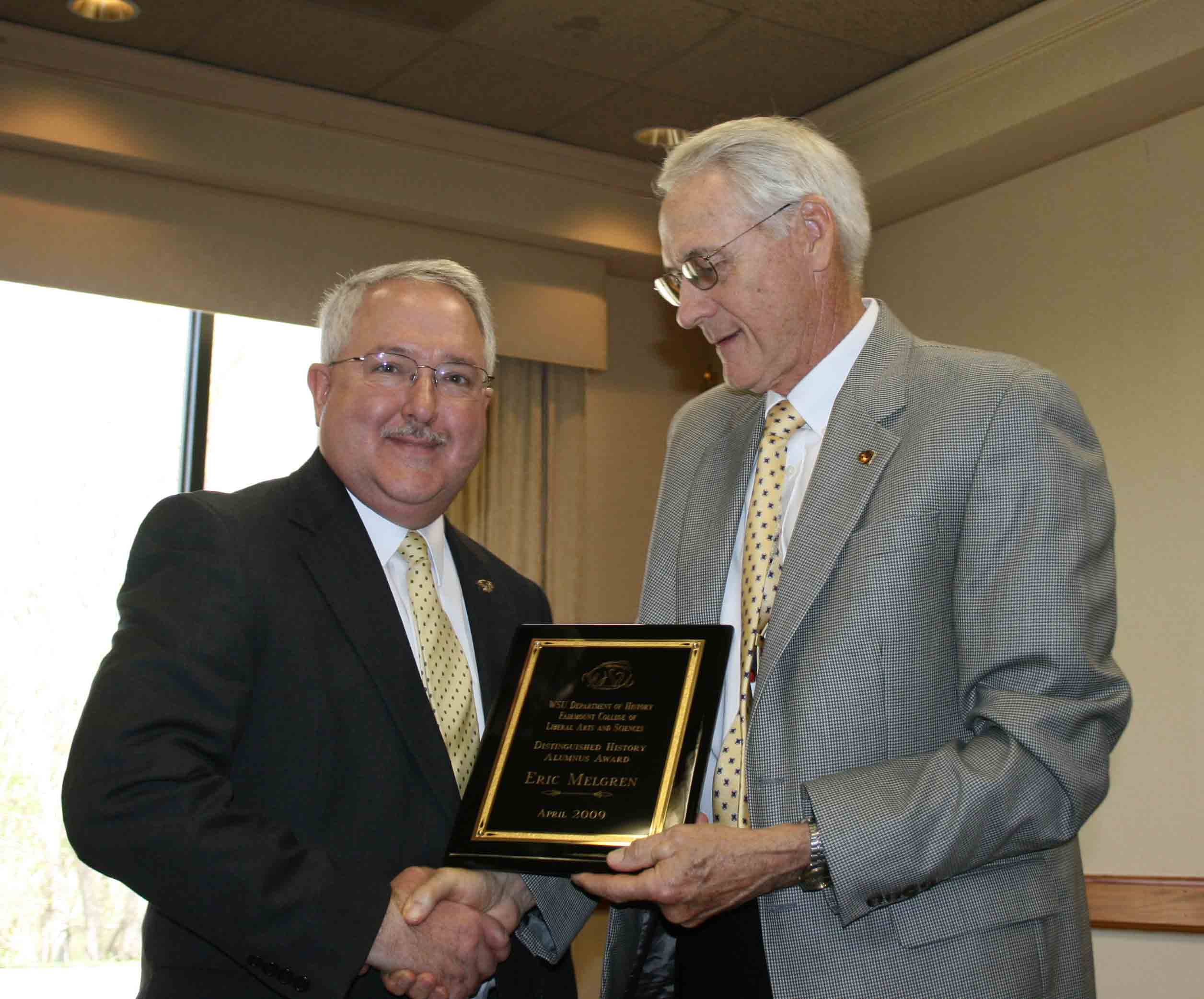 Photo of Eric Melgren receiving the department's 2009 Distinguished History Alumni Awared from Dr. John Dreifort. 