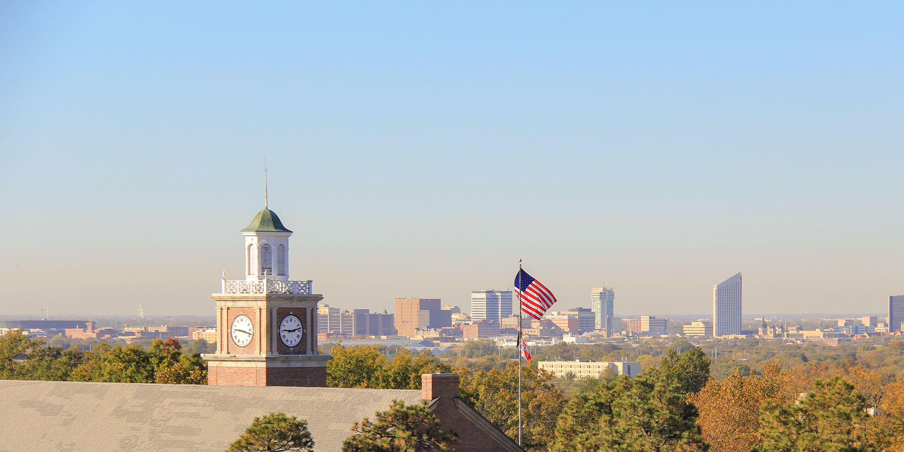 photo of WSU Morrison Hall clock tower and downtown skyline of wichita