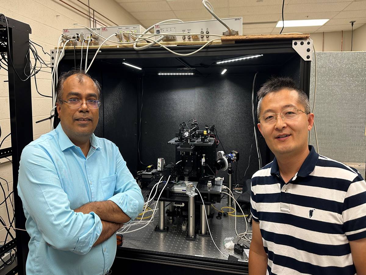 Kapildeb Ambal and Jian Wang stand in front of a single-spin quantum microscope used to study quantum materials. 