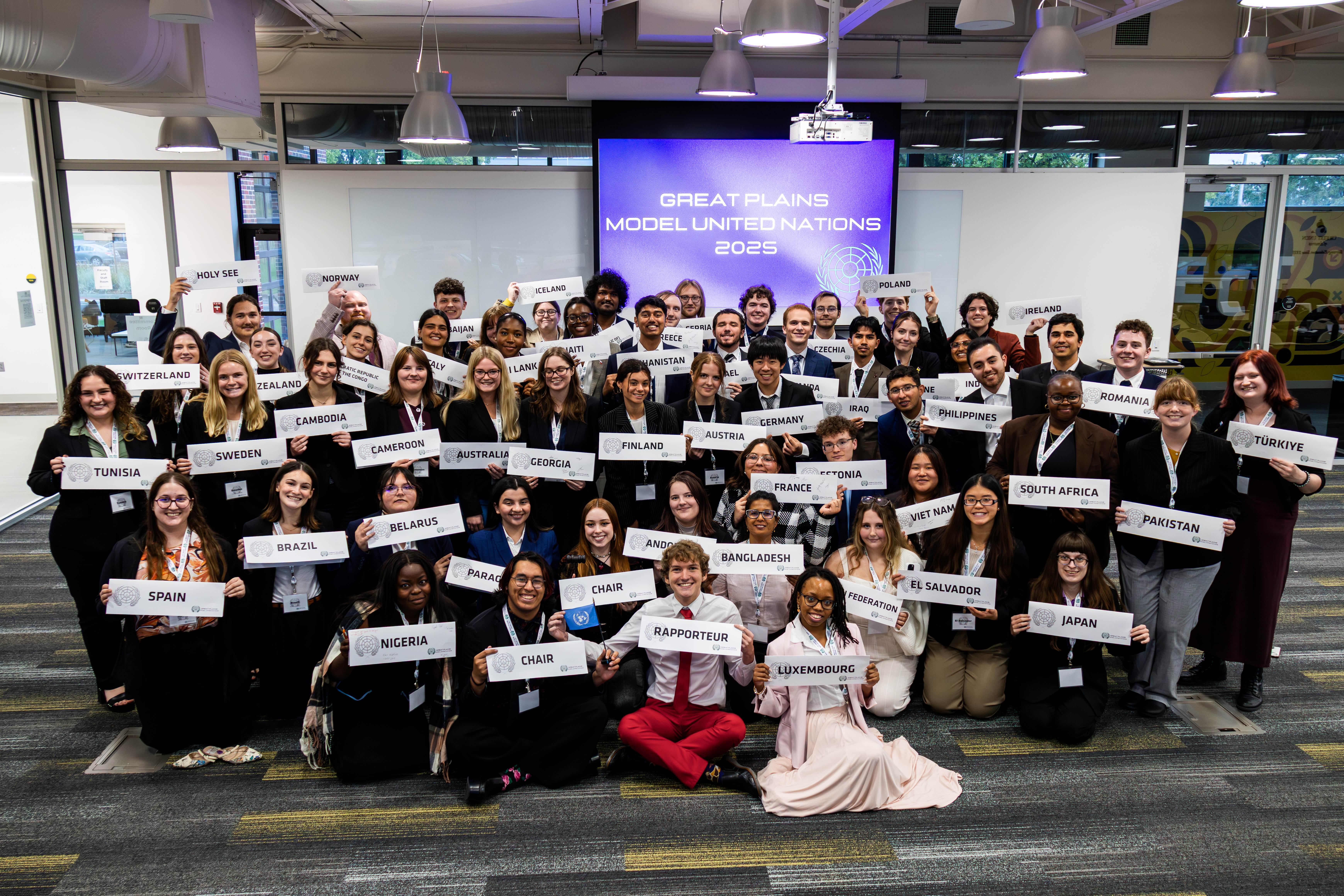 Students gathered at the Great Plains Model United Nations event holding their placards