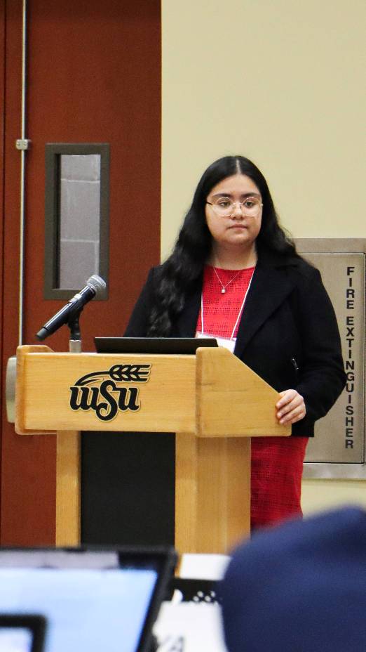 Student standing and speaking at a podium