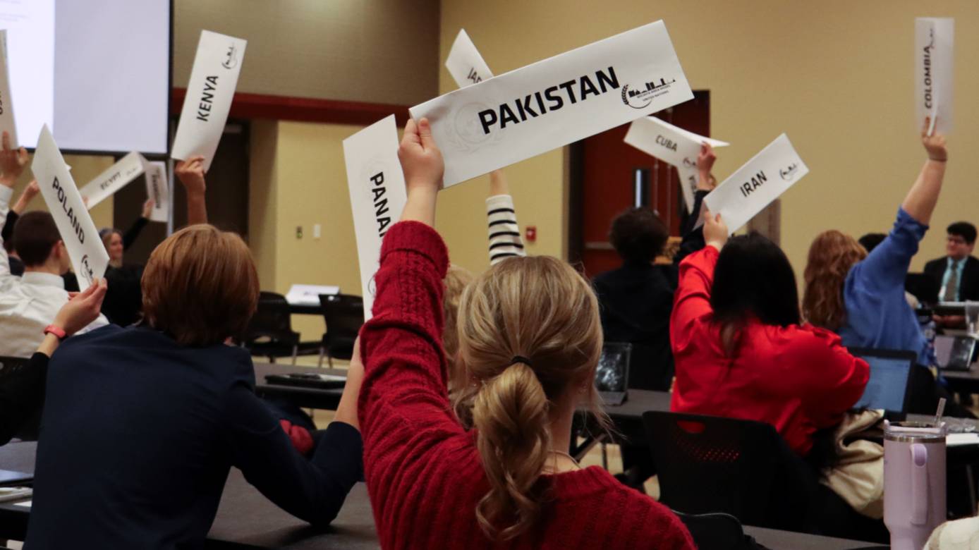 Students raising the signs for their designated country