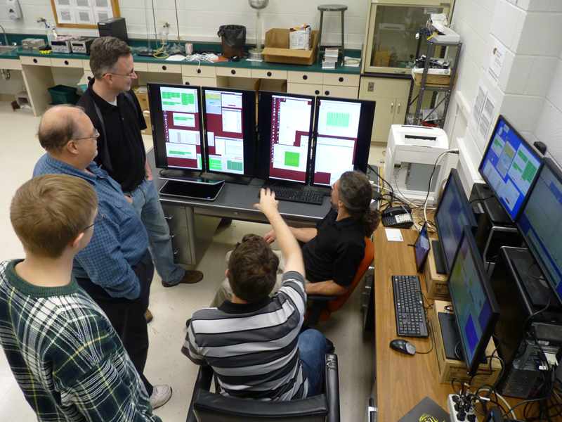 Physics professors and students study incoming data