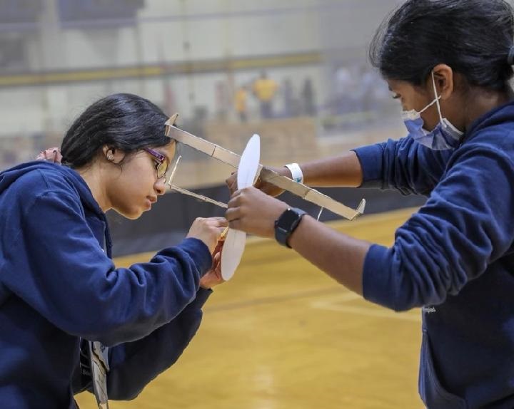 Two students complete and prepare their aircraft in the flight competition 