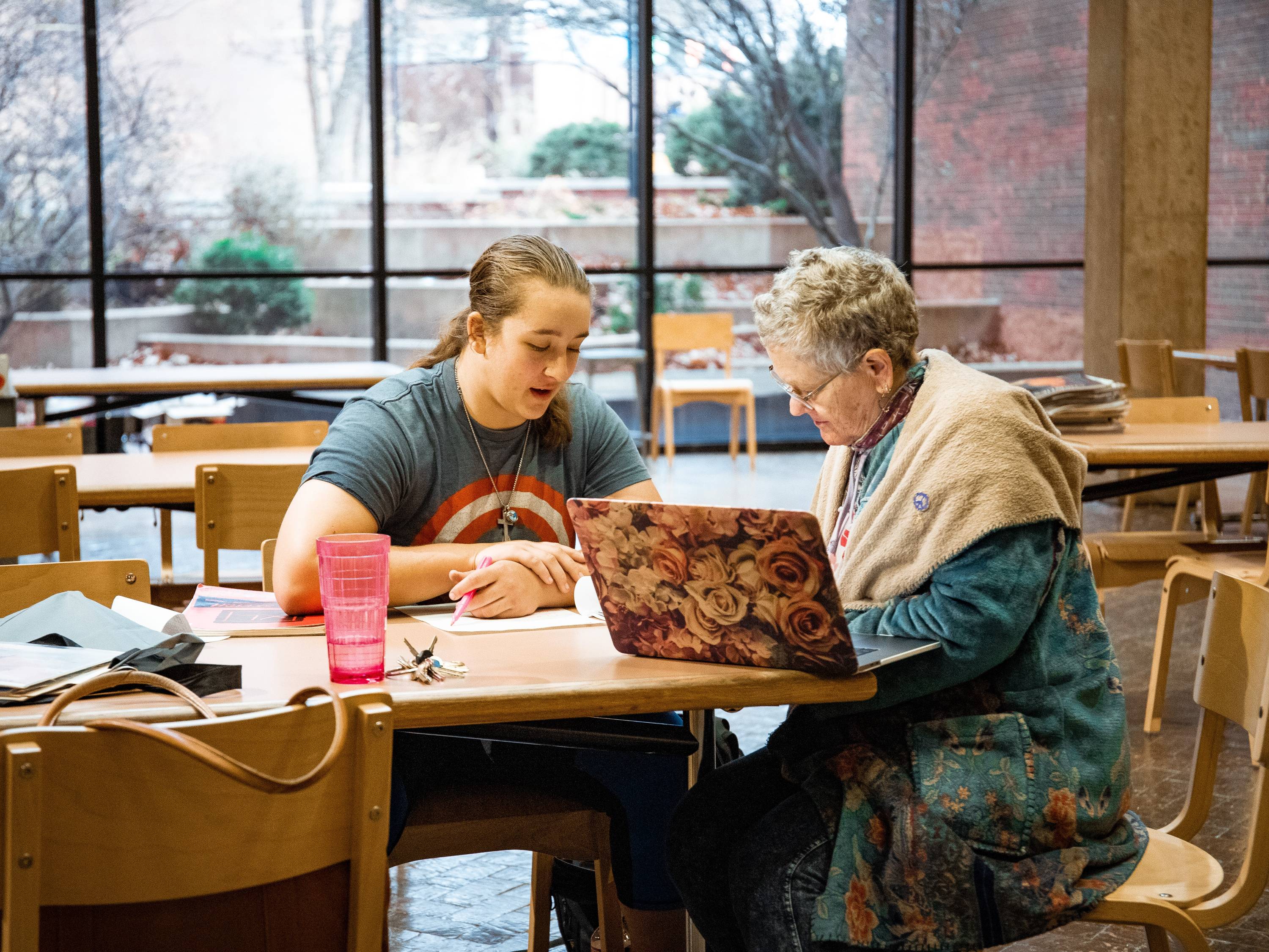 Young student and older woman collaborate on a laptop at Wichita State University.