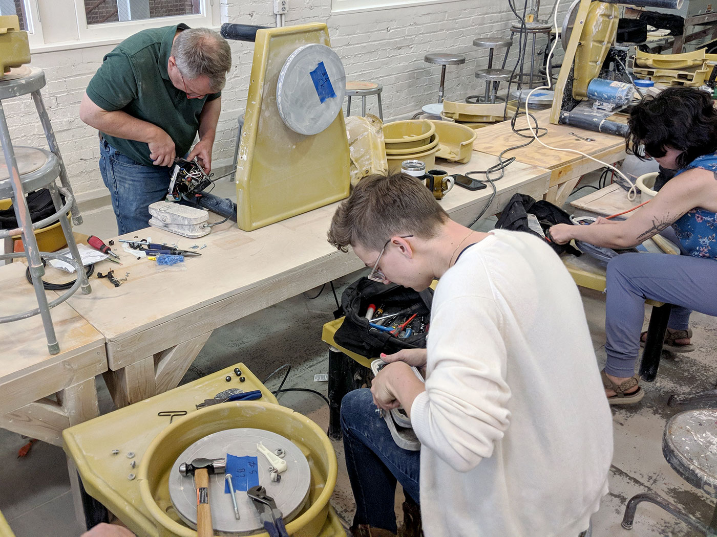 A group of people work on repairing Brent wheels