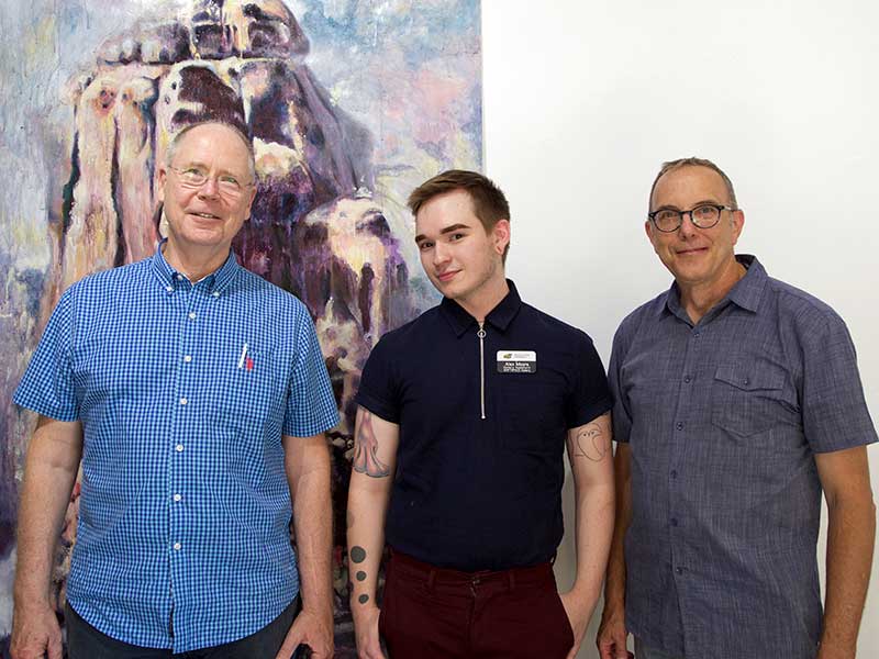 Art & Design Advocates board members Richard Overby and Mat Buckingham post with 2018 BFA graduate Alex Moore at his ShiftSpace Gallery exhibition.