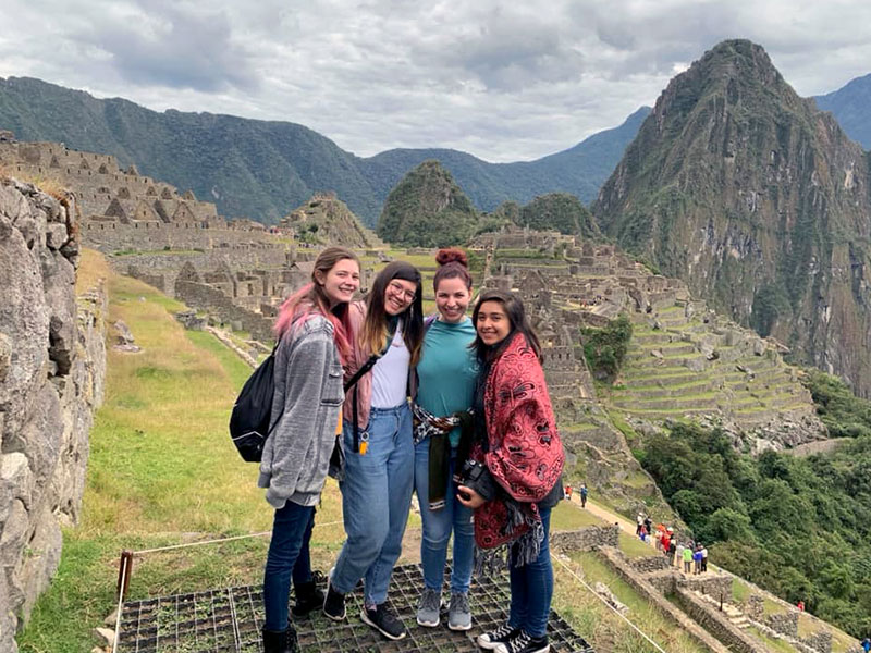 Bishop Rice, Celine Sengvilay and Lily Guillen pose with their arms around each other in front of Machu Piccu, the 15th century Incan citadel located in the Andes mountains.