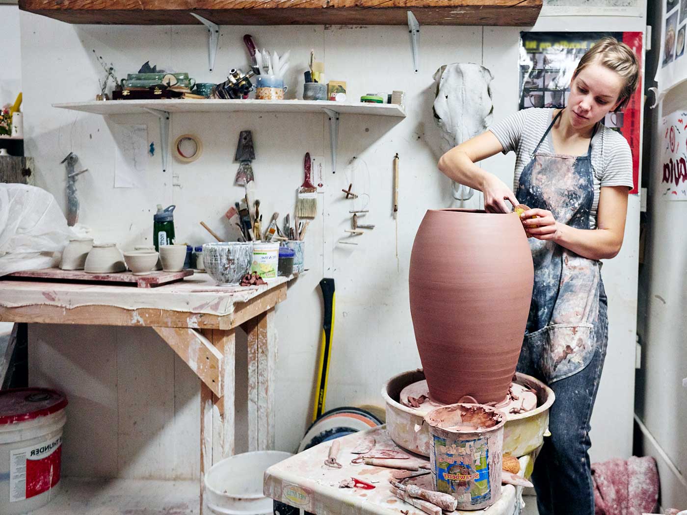 Laura Nave works with a large wheel-thrown vase in her Henrion Hall studio.