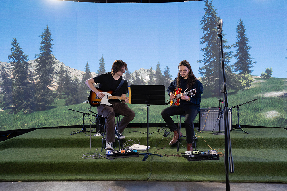 Guitar duo in front of a LED sceen.