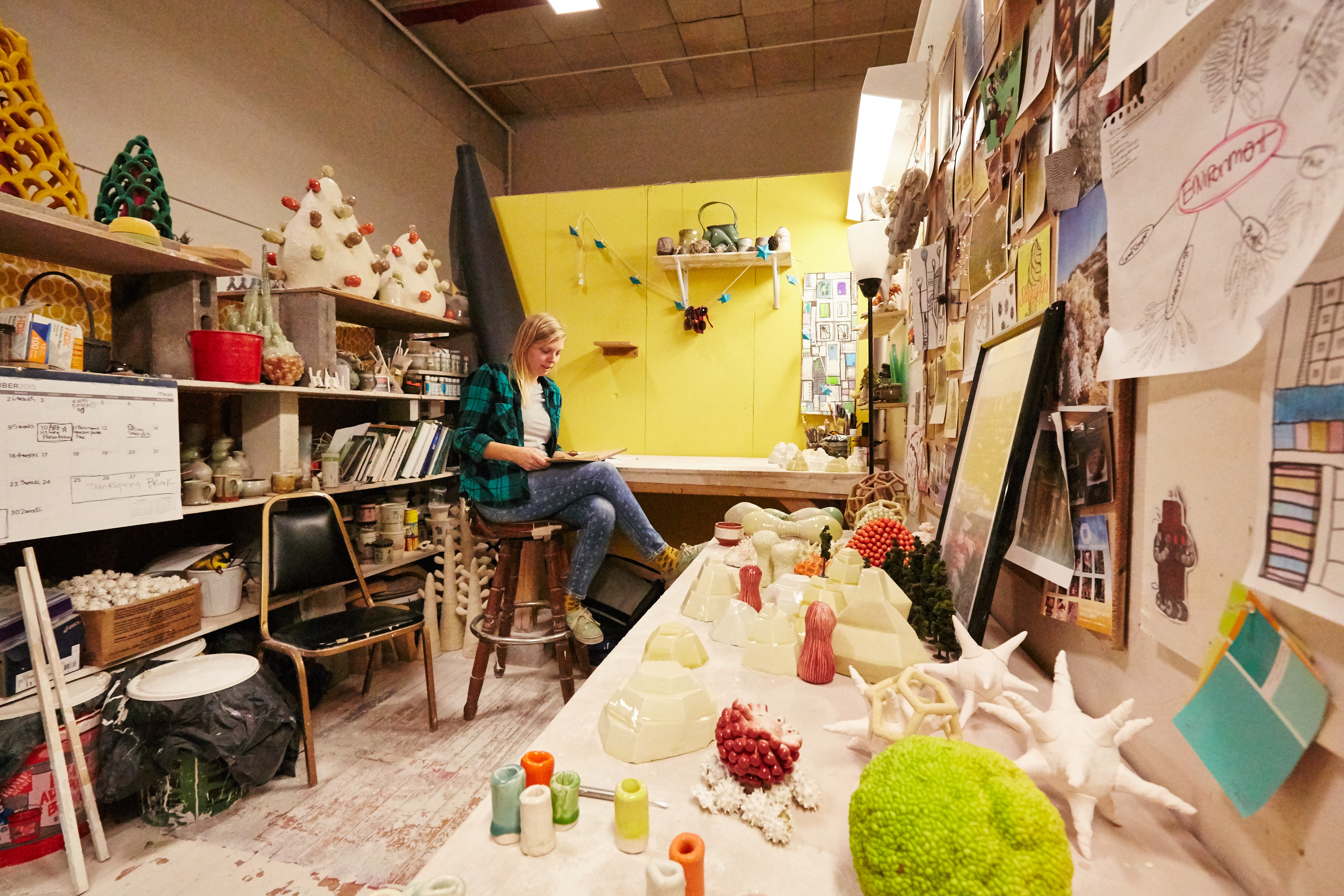 Graduate student sits in private ceramics studio.