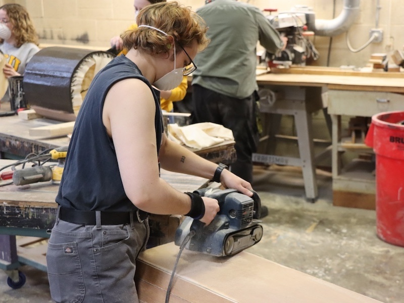 Twelfth Night workday student in scene shop working on a set
