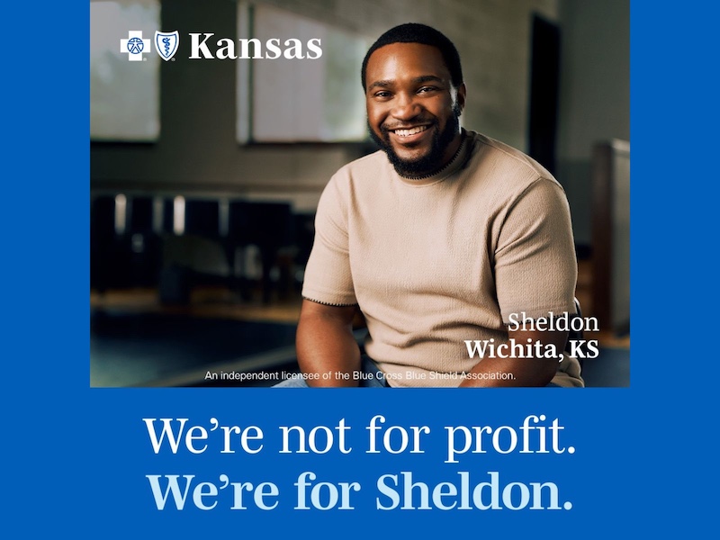 Sheldon Mba for Blue Cross Blue Shield commercial Sheldon sitting & smiling at the camera