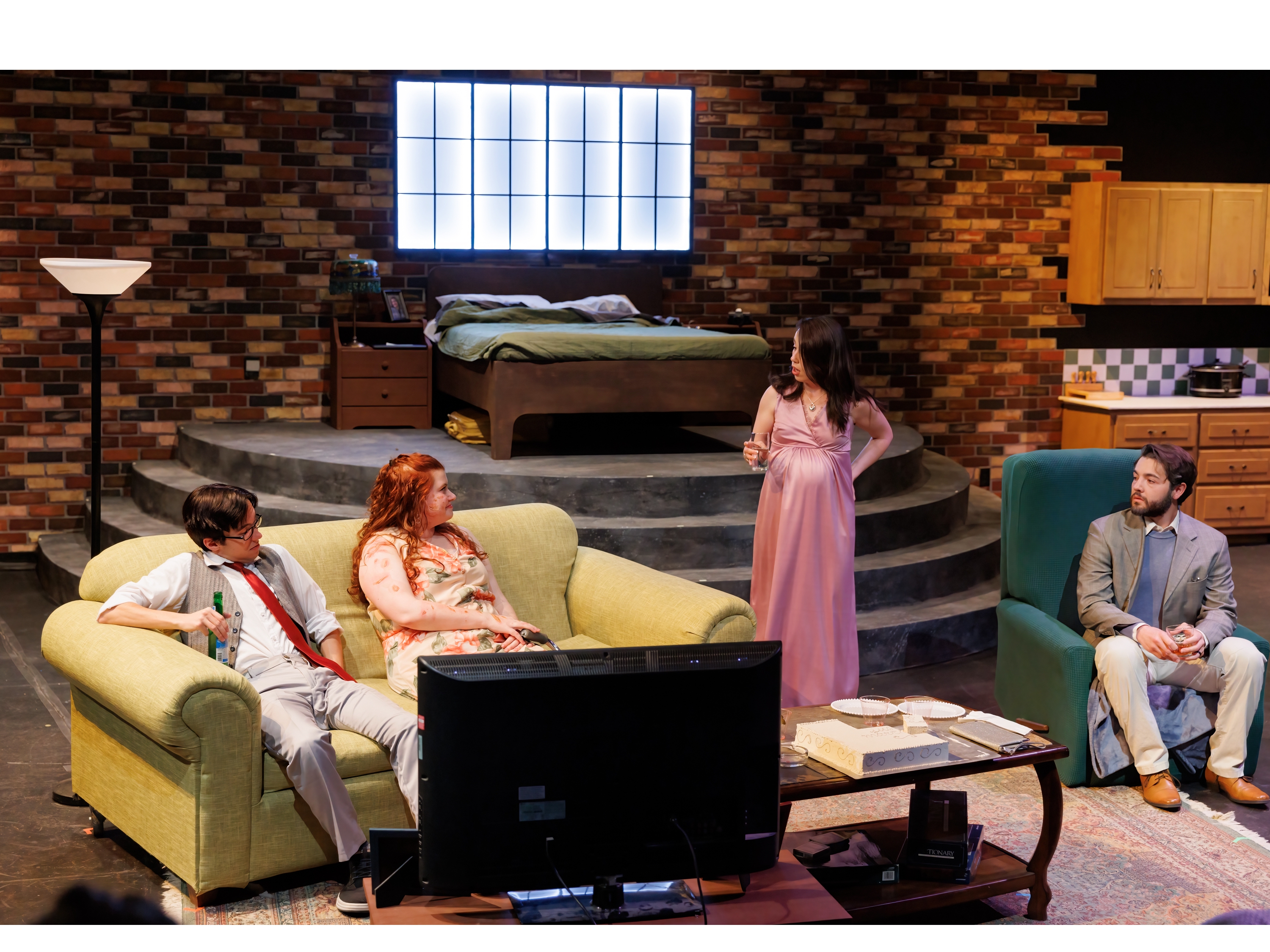 man and woman on a couch talking with a pregnant woman and man in a chair from the 2026 production of Time Stands Still