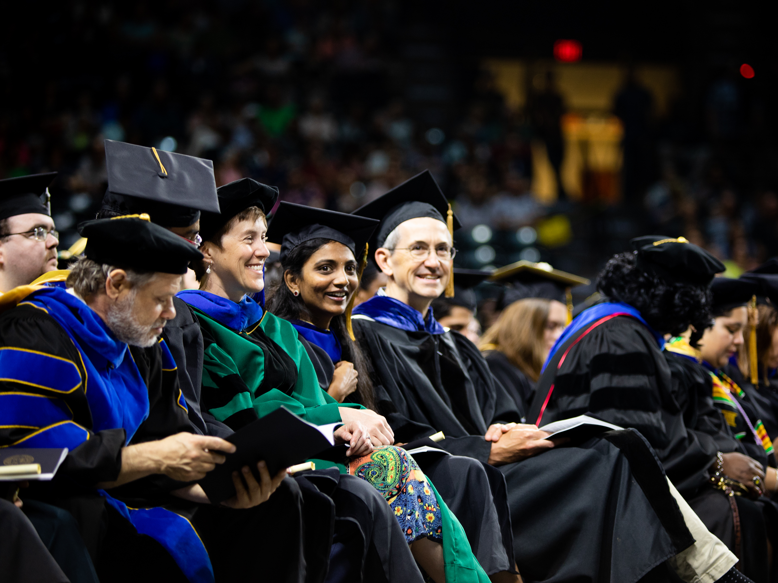 Graduates and faculty on the commencement floor at Charles Koch Arena