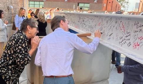 People signing beam at beam signing ceremony People signing beam at beam signing ceremony