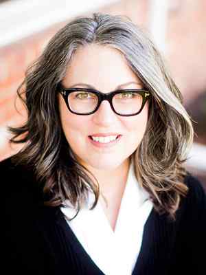 Headshot photo of Dr. Amy Drassen Ham in a black blouse with white collar and black glasses frames.
