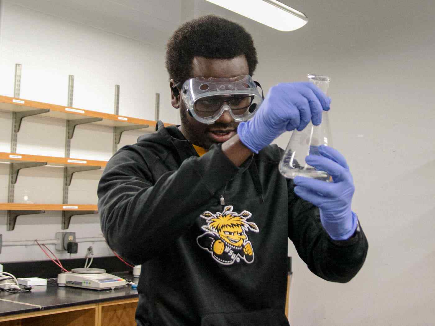Student measuring fluid in the lab.