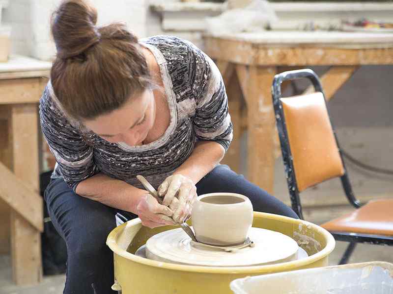 Renee Fritts throwing clay pot on ceramics wheel.