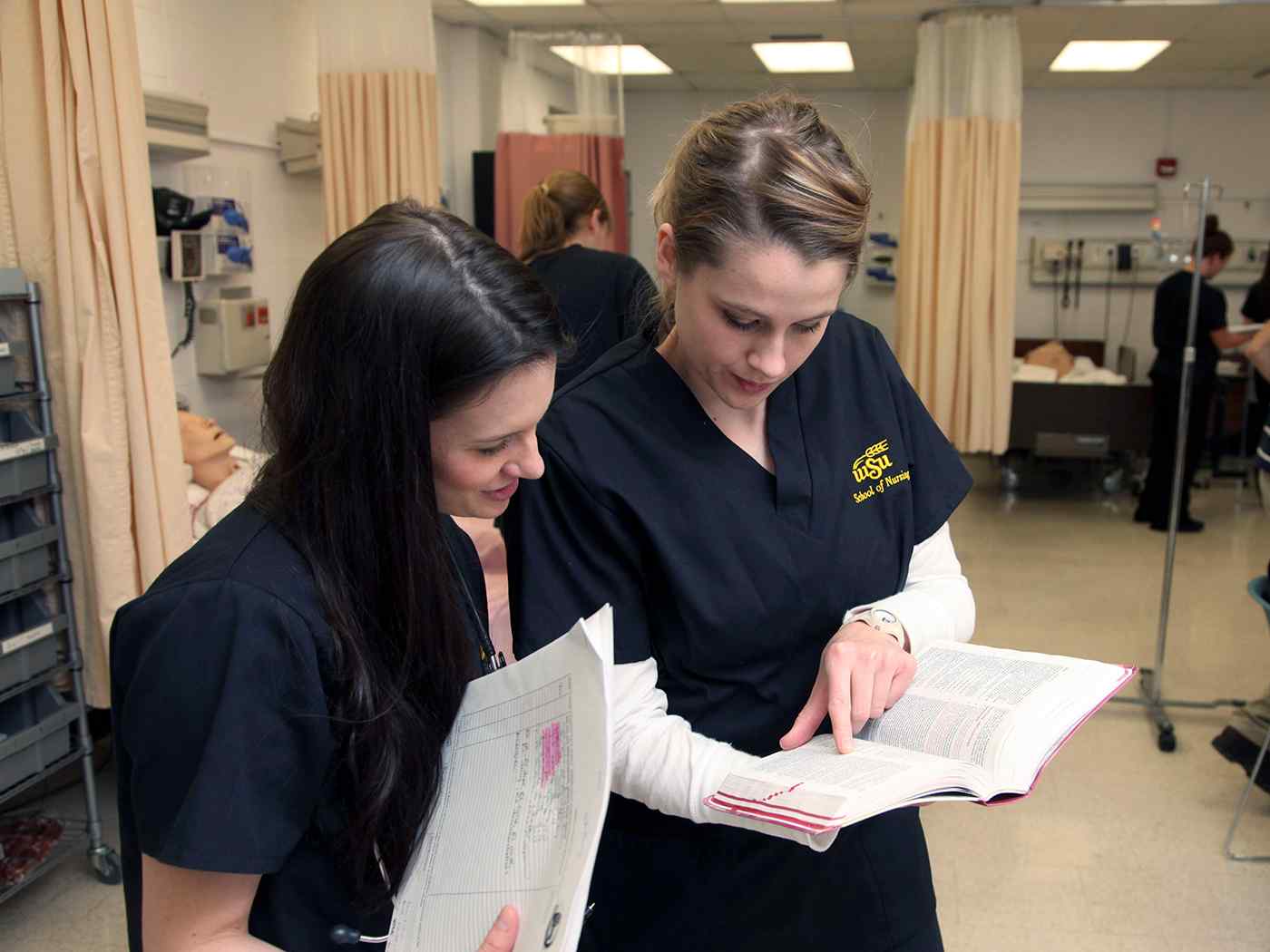 Two nursing students review a chart