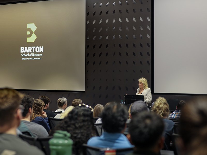 The Barton School's Entreprenuer in Residence standing at a podium to deliver a lecture in Woolsey Hall.