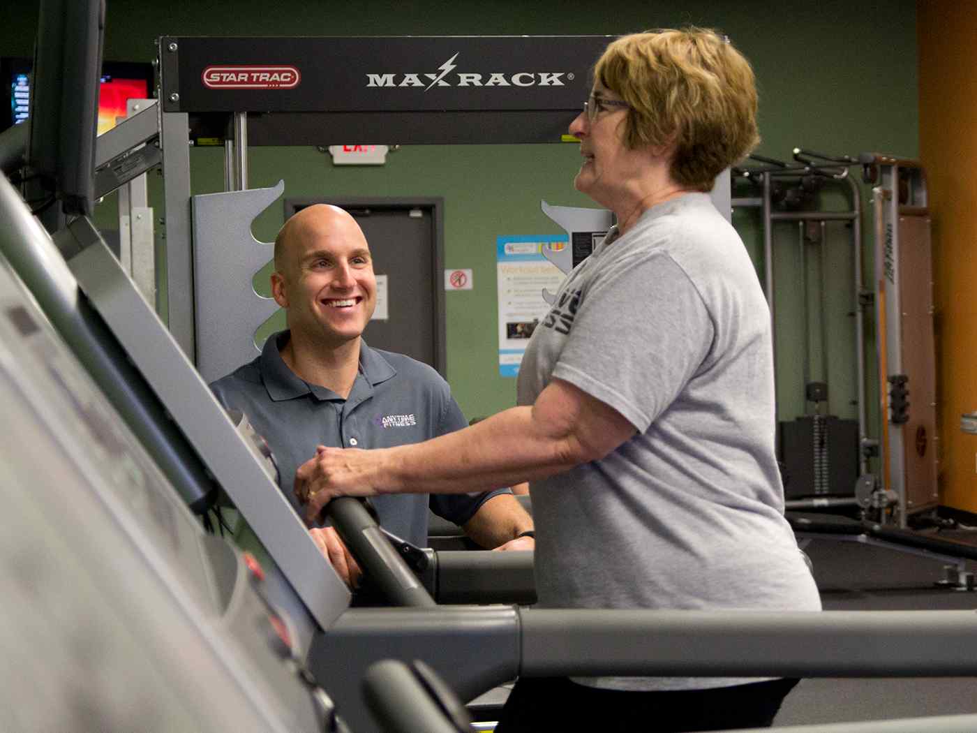 Older woman with trainer on treadmill.