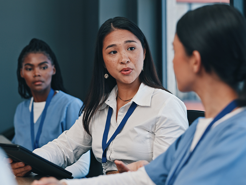 A group of health care professionals meets in a conference room.