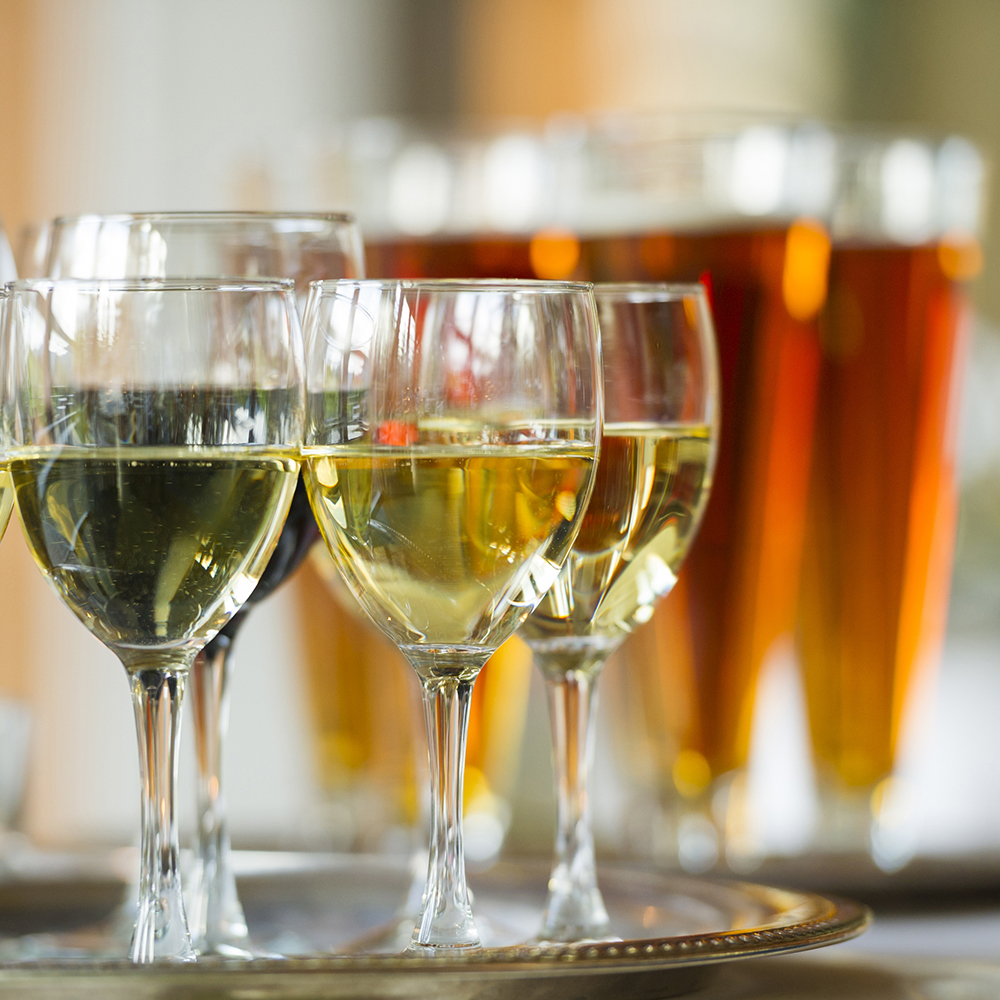 Beer and wine glasses on serving trays at an event