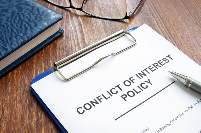 Conflict of Interest Policy on a clipboard.