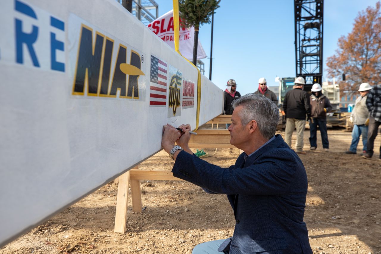 President Rick Muma signs on of the beams for the HAMR construction
