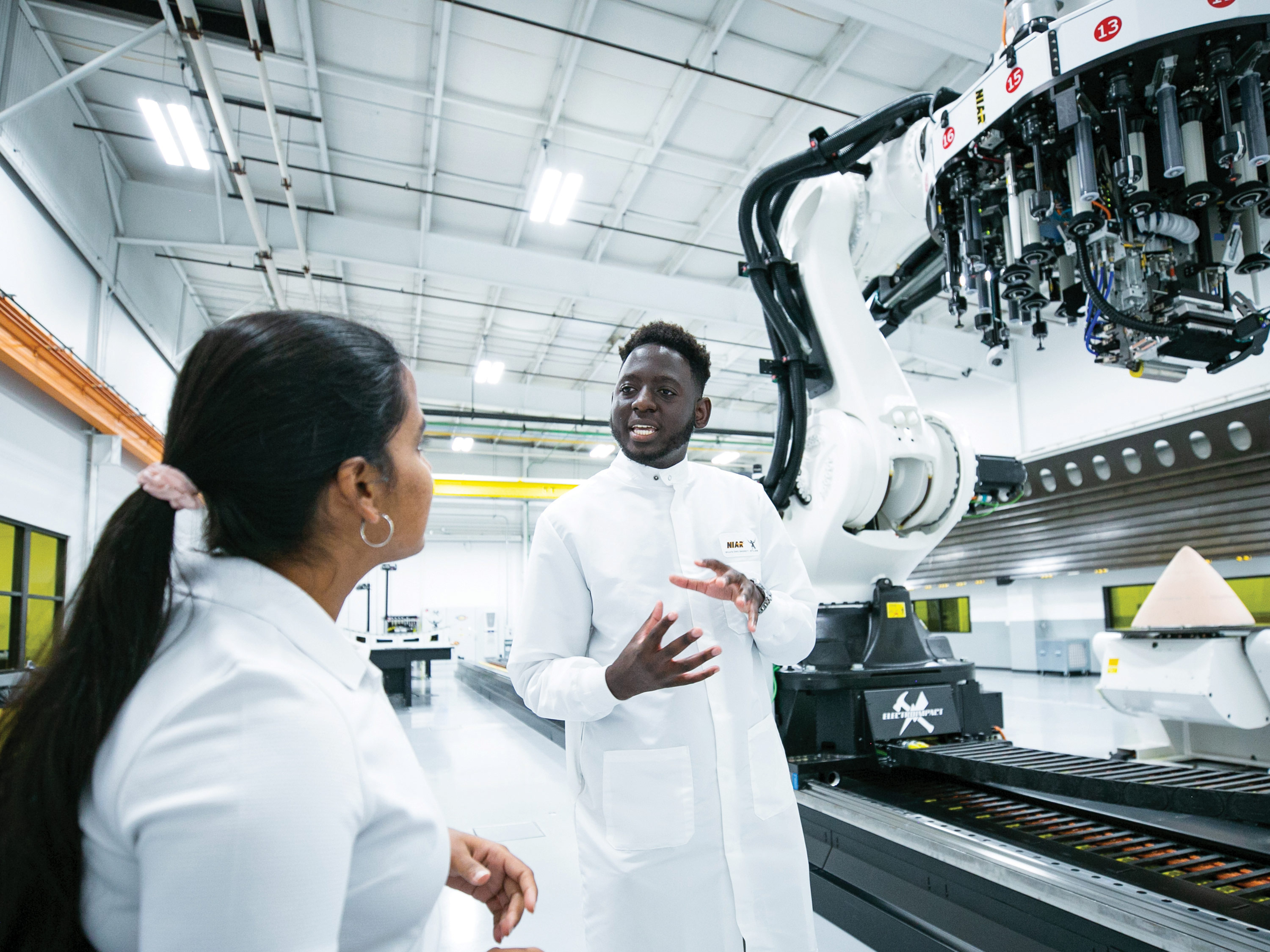 Two students talk in an engineering lab.