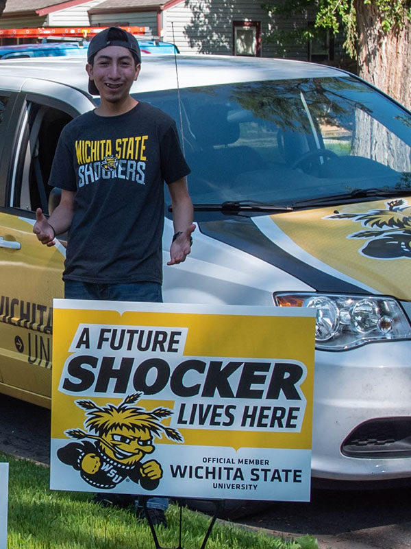 A male student poses with his future shocker yard sign