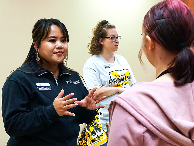 Trang Tieu, Manager, Adivsing & Student Impact for the Office of Financial Aid, and Amanda Duffy, Financial Aid Advisor, chat with a prospective student during a Fall 2023 Black & Yellow Day.