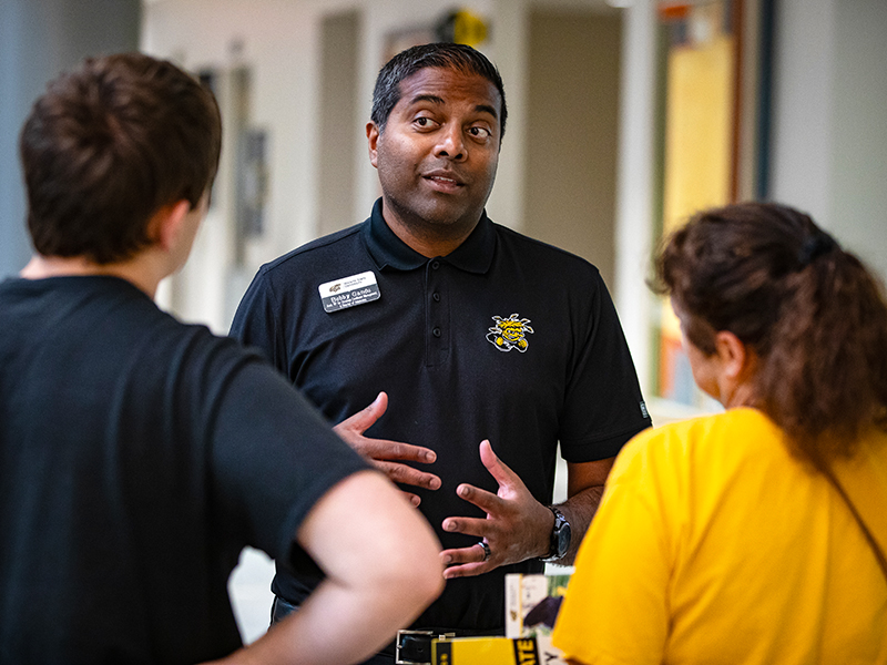 Bobby Gandu, Associate VP for Strategic Enrollment Management, Applied Learning & Director of Undergraduate Admissions, talks with a student and parent at Wichita State Activate.